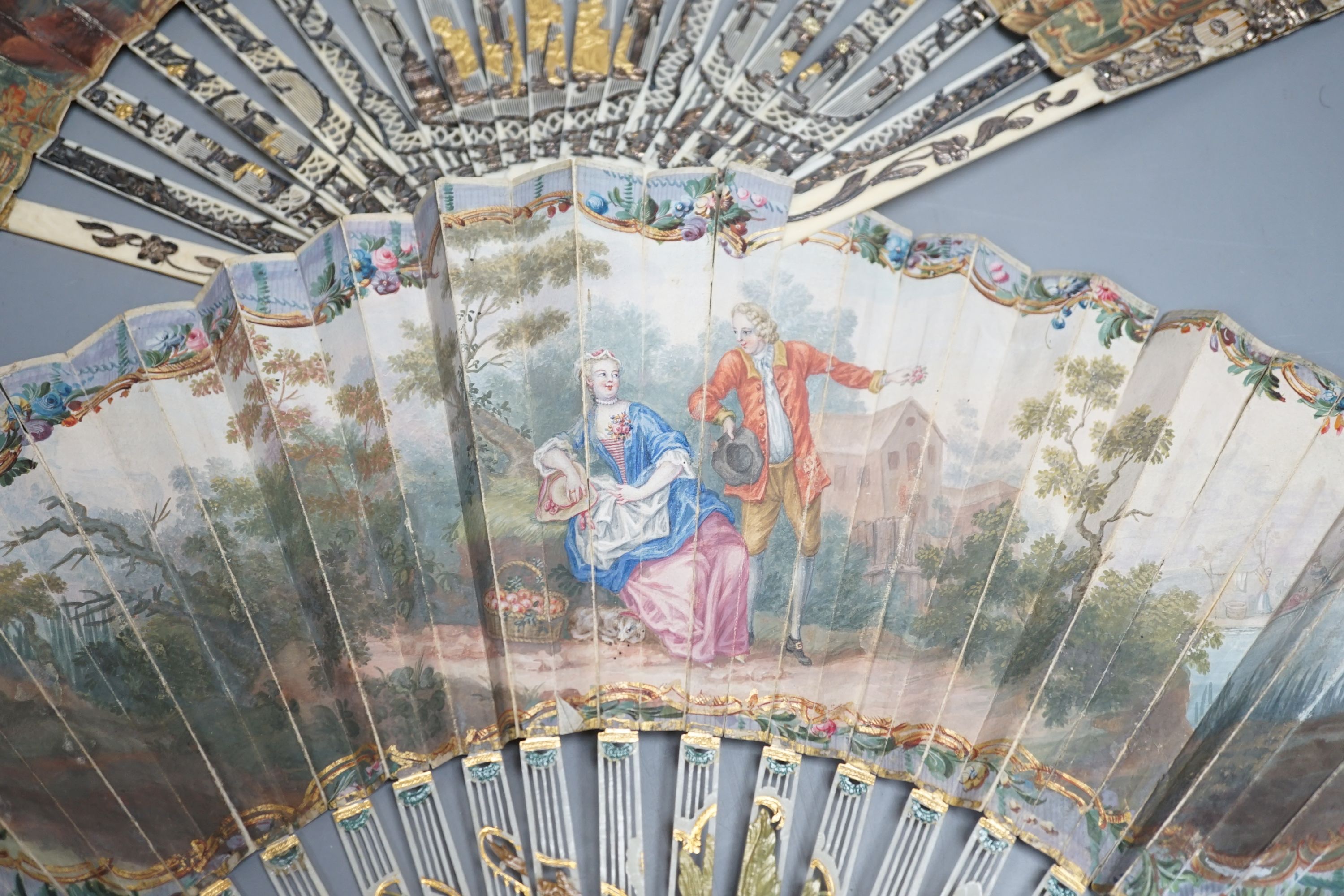 Two late 18th/early 19th century French gilded and silvered ivory and painted paper leaf fans